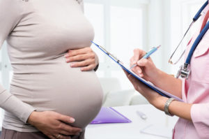Pregnant woman consulting with her doctor during a prenatal checkup.