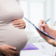 Pregnant woman consulting with her doctor during a prenatal checkup.